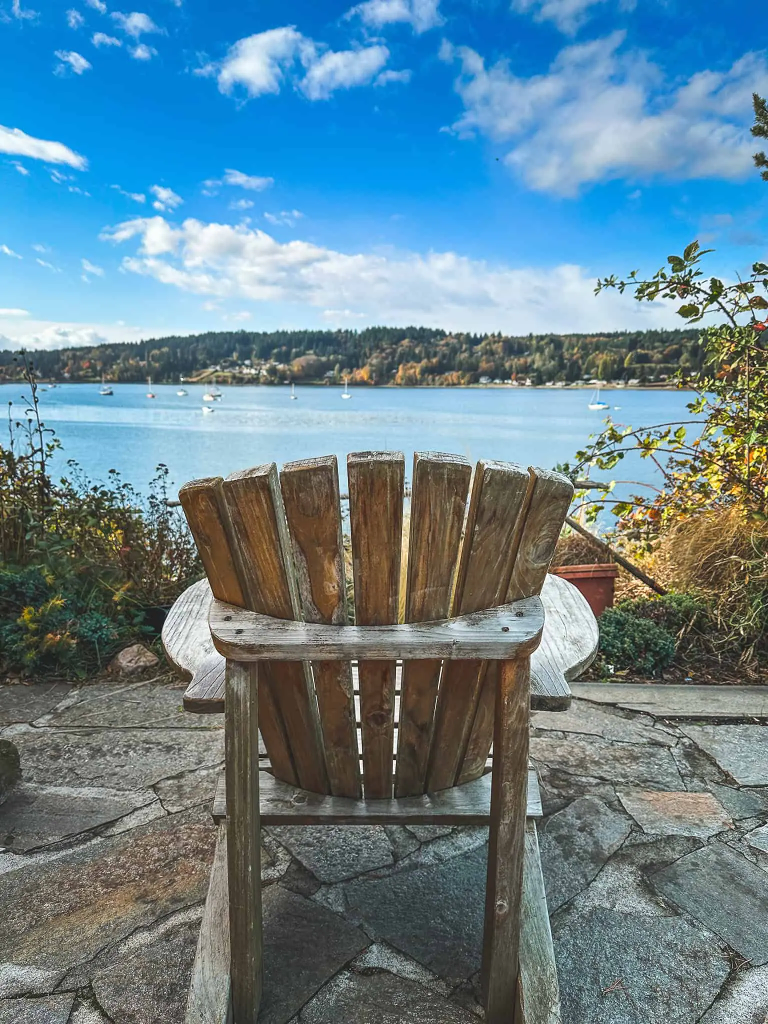 Wooden chair overlooking Poulsbo harbor and scenic waterfront view.